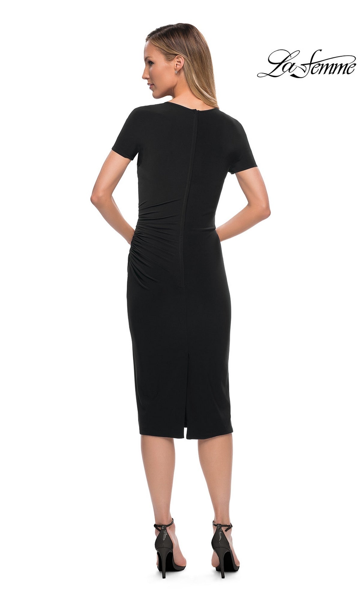 Back view of a black Knee Length Wedding Guest Dress: La Femme 29510 with short sleeves, ruched waist, and back zipper, paired with black high-heeled sandals.