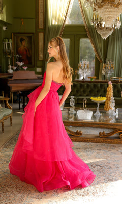 A woman wearing the Ava Presley 29524 strapless long prom ball gown stands in an elegant, vintage-style room with green walls, chandeliers, and classic furniture.