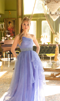 A young woman stands in an elegant, sunlit room with chandeliers and classical décor, wearing the Ava Presley 29534 Beaded-Waist Long Prom Dress.