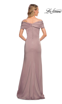A woman is shown from the back wearing the La Femme 29537 long formal dress, an off-the-shoulder, floor-length mauve gown. This fitted sheath style features subtle draping and a gracefully contoured silhouette that embodies minimalist chic elegance. The “La Femme” logo appears in the top right corner.