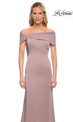 A woman stands against a plain white background, dressed in the La Femme 29537—a minimalist chic, off-the-shoulder mauve long formal gown—with minimal accessories.