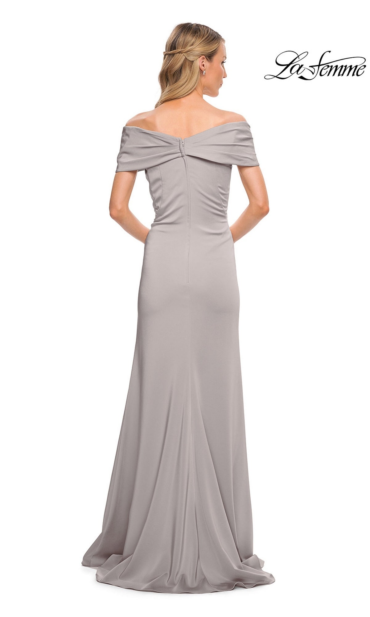 A woman faces away in the La Femme 29537 long formal dress—a light gray, off-the-shoulder, floor-length design with minimalist chic style, a fitted bodice, and a slight train. The “La Femme” logo in cursive appears at the top right corner.