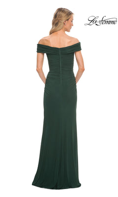 A blonde woman models the Long Formal Dress: La Femme 29541, featuring a ruched fitted bodice and off-the-shoulder neckline, shown from the back on a white background.