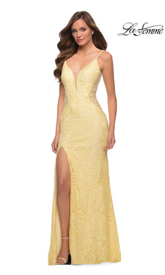 A woman wears the pale yellow Long Prom Dress: La Femme 29679, a floor-length stretch-lace gown with a deep V-neckline, spaghetti straps, and a high side slit.