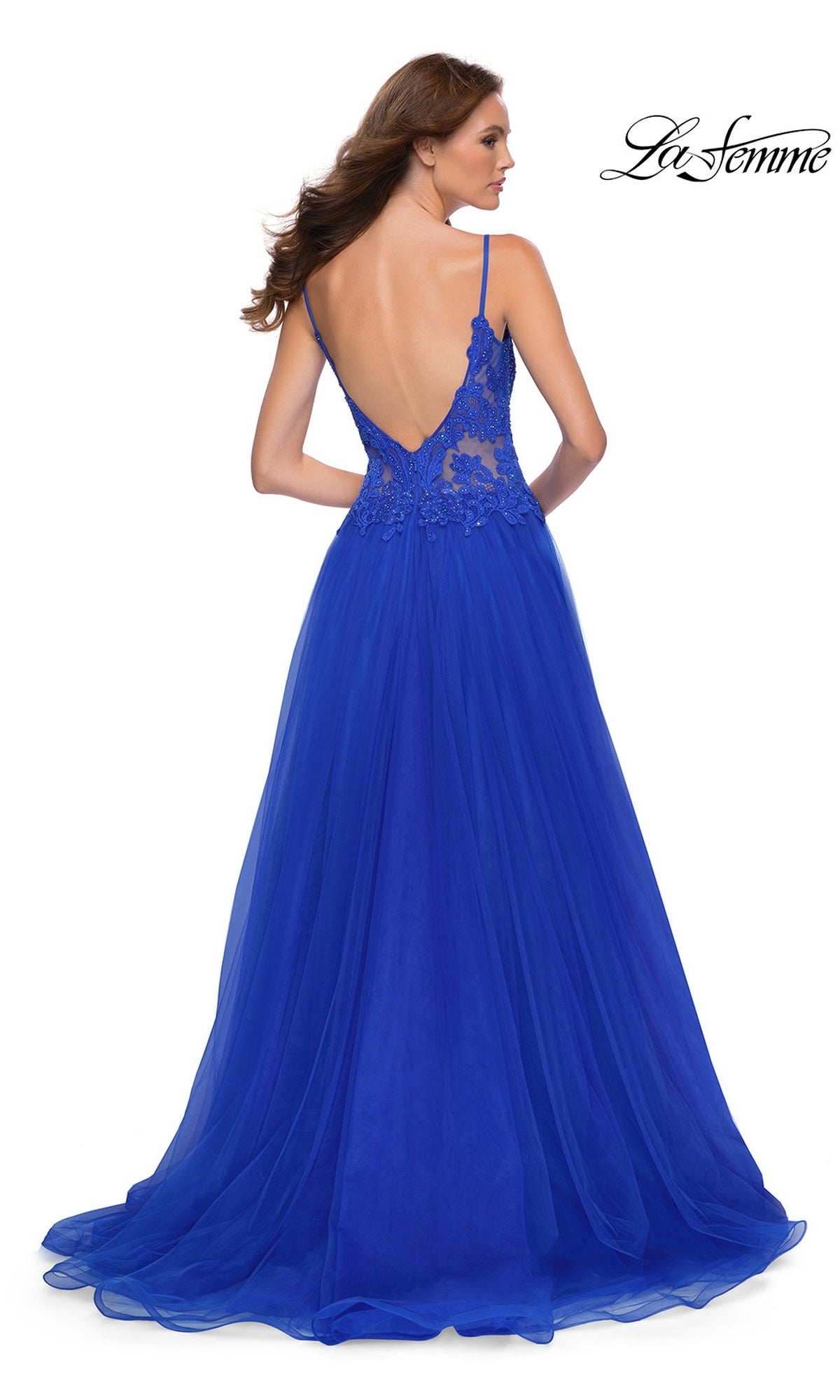 A woman stands with her back to the camera in the La Femme Lace-Bodice Long A-Line Prom Dress 29686, featuring royal blue embroidered lace, a deep V-back, and thin straps. 