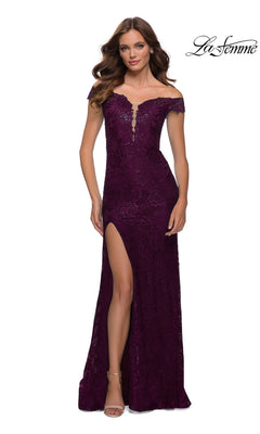 Woman wears Long Prom Dress: La Femme 29693 in Dark Berry with stretch lace, off-shoulder neckline, fitted bodice, high side slit, and slight train, standing facing forward.