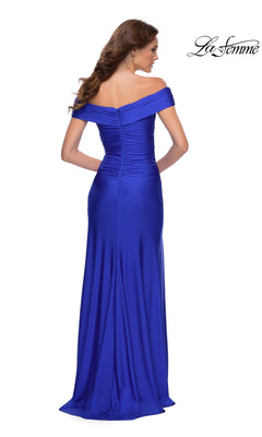 A woman elegantly photographed from the back wears the La Femme Long Prom Dress 29781, a floor-length royal blue off-the-shoulder gown with ruched detailing.