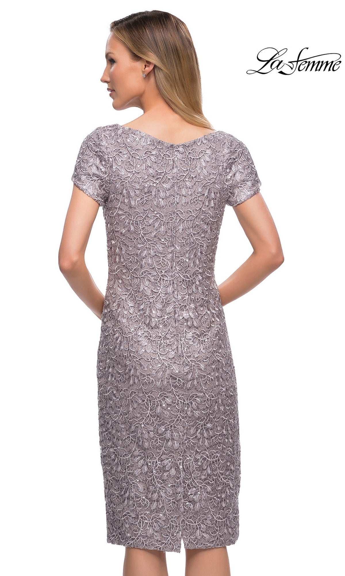 A woman wears a Knee Length Wedding Guest Dress: La Femme 29809, a dark mauve knee-length dress featuring an intricate lace overlay.