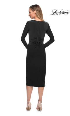 A woman seen from behind wearing a black long-sleeved Midi Wedding Guest Dress: La Femme 29812 with center-back ruching and nude high-heeled sandals.
