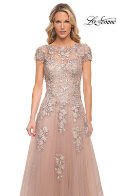 La Femme 29829 is a floor-length blush formal dress with a cap-sleeve bodice featuring sheer floral embroidery over a light pink skirt.