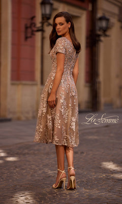 Woman wearing the Midi Mother of Bride Dress: La Femme 29830, standing on a cobblestone street and looking over her shoulder.