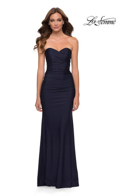 A woman wearing a navy La Femme 29851 long prom dress featuring a strapless, floor-length design with a ruched bodice and a sweetheart neckline.