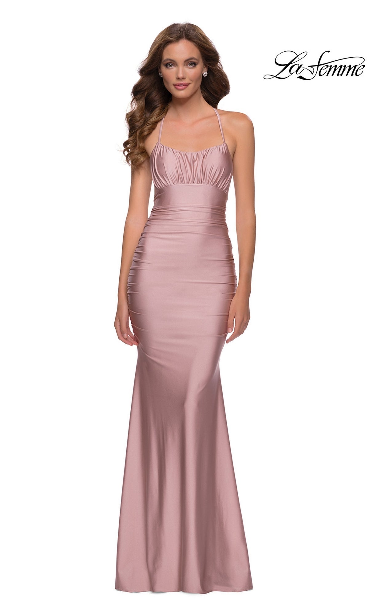 Woman in a sleeveless blush pink La Femme Ruched-Bust Long Prom Dress 29873 with thin straps, slight ruching at the bodice, and a fitted silhouette. 