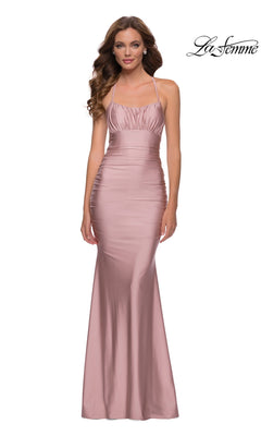 Woman in a sleeveless blush pink La Femme Ruched-Bust Long Prom Dress 29873 with thin straps, slight ruching at the bodice, and a fitted silhouette. "La Femme" logo appears in the top right corner to accent this elegant look.