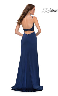 A woman wearing a La Femme 29888 floor-length navy prom dress with a backless bodice and beaded straps.