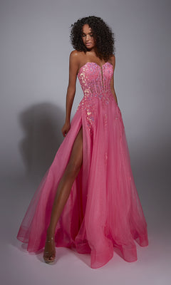 A woman poses against a plain background wearing the Aerie Couture 298 Glitter Tulle Prom Ball Gown, a strapless bright pink dress featuring floral lace embroidery, a sheer bodice, glitter tulle details, and a high leg slit.