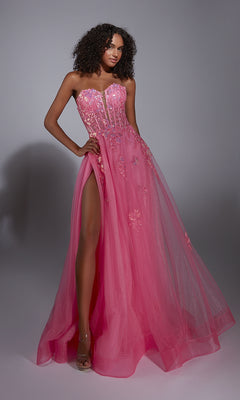 A woman models the Aerie Couture 298 Glitter Tulle Prom Ball Gown—pink, strapless, with floral lace embroidery and a thigh-high slit—standing against a plain gray background.