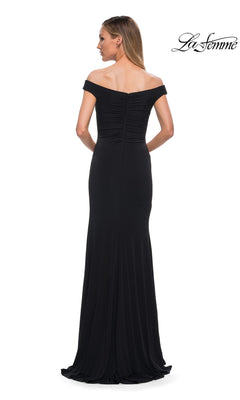 Back view of a woman wearing the Long Formal Dress: La Femme 29925, a floor-length, black ruffled off-the-shoulder gown with a ruched bodice.