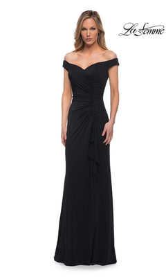 A woman wearing a black Long Formal Dress: La Femme 29925, featuring an off-the-shoulder formal design with a ruched bodice, floor-length hem, and side slit.