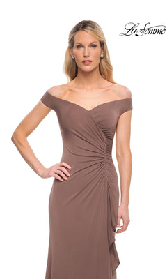 A model wears a La Femme 29925 taupe, floor-length, off-the-shoulder gown featuring ruffled detailing and side-ruched accents at the waist.