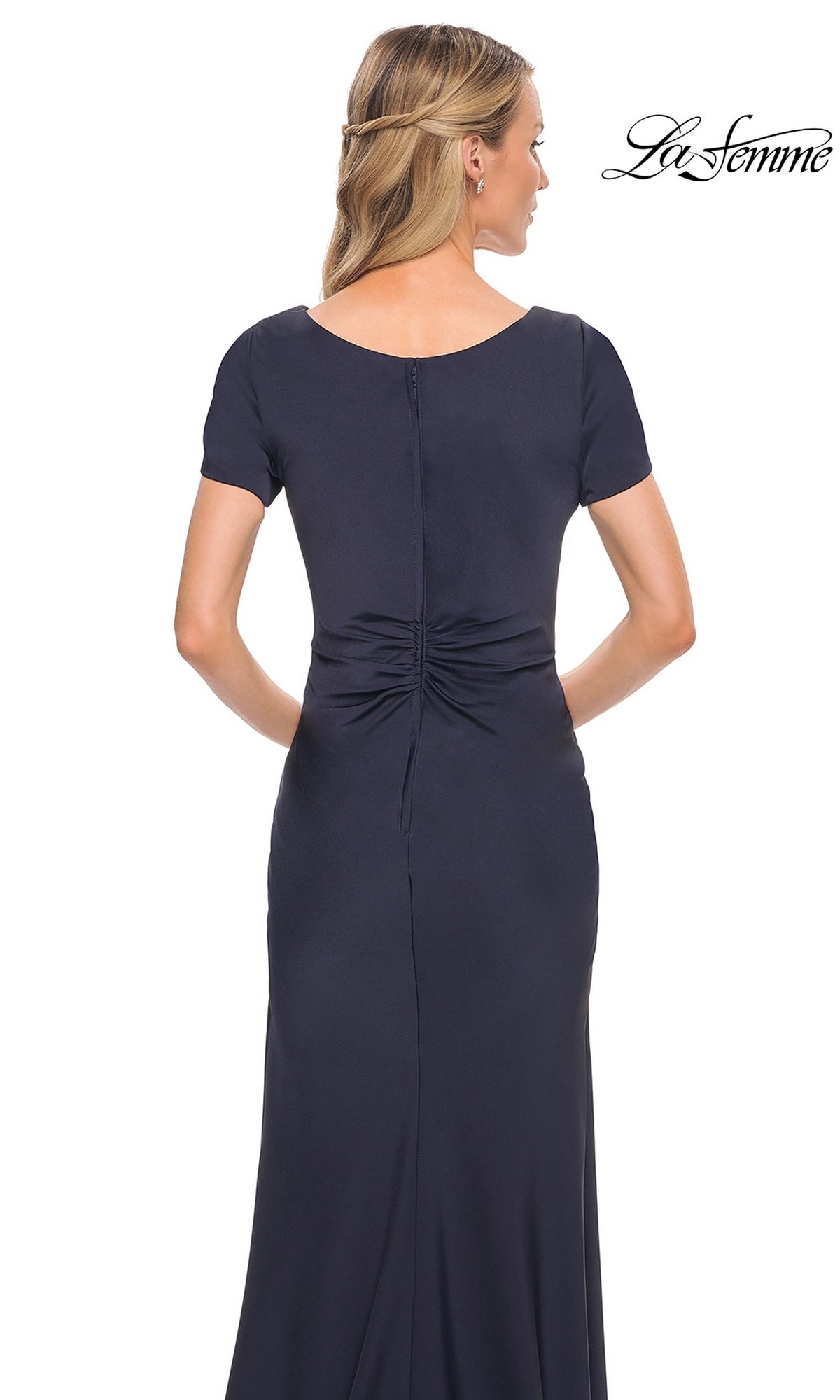 Back view of the Long Formal Dress: La Femme 29926, a modest, floor-length navy blue gown with short sleeves and a twist-knot gathered waist.
