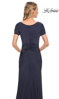 Back view of the Long Formal Dress: La Femme 29926, a modest, floor-length navy blue gown with short sleeves and a twist-knot gathered waist.
