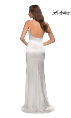 A woman in the La Femme Open-Back Simple Long Prom Dress 29945, featuring white satin, thin straps, and an open back, stands facing away from the camera. The La Femme logo appears in the top right corner.