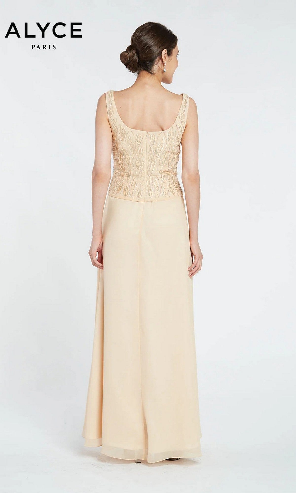 A woman models the Long Formal Dress: Alyce 29953, a sleeveless, light beige gown with an embroidered, beaded top. She stands facing away against a plain white background. The 