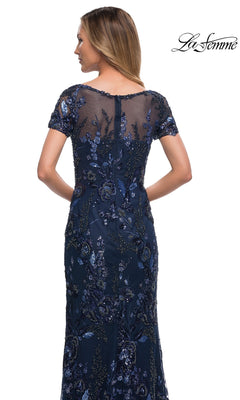 Woman wearing Long Formal Dress: La Femme 29961—navy blue, short sleeves, floral sequin embroidery—shown from the back. “La Femme” logo top right.