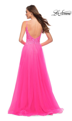 A woman seen from behind wearing a La Femme 29964 neon pink A-line prom dress with a lace bodice and a low-cut back.