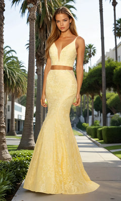 Woman in a yellow evening gown standing on a palm tree-lined street.