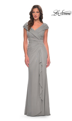 A woman wears a silver Long Formal Dress: La Femme 29996, featuring a V-neck, cap sleeves, and a draped bodice with a side ruffle.