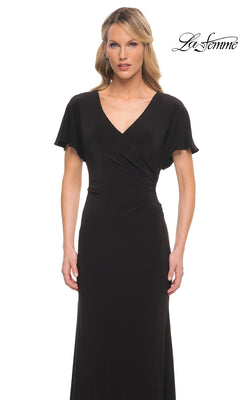A woman wearing a Long Formal Dress: La Femme 29997, a floor-length jersey formal dress with a V-neckline, short flutter sleeves, and gathered waist detailing.
