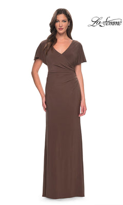 A woman wears a cocoa-colored La Femme 29997 floor-length jersey formal dress with a V-neck and flutter sleeves.