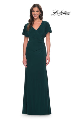 A woman wearing a hunter green Long Formal Dress: La Femme 29997 featuring a floor-length jersey design with short flutter sleeves and a V-neckline.