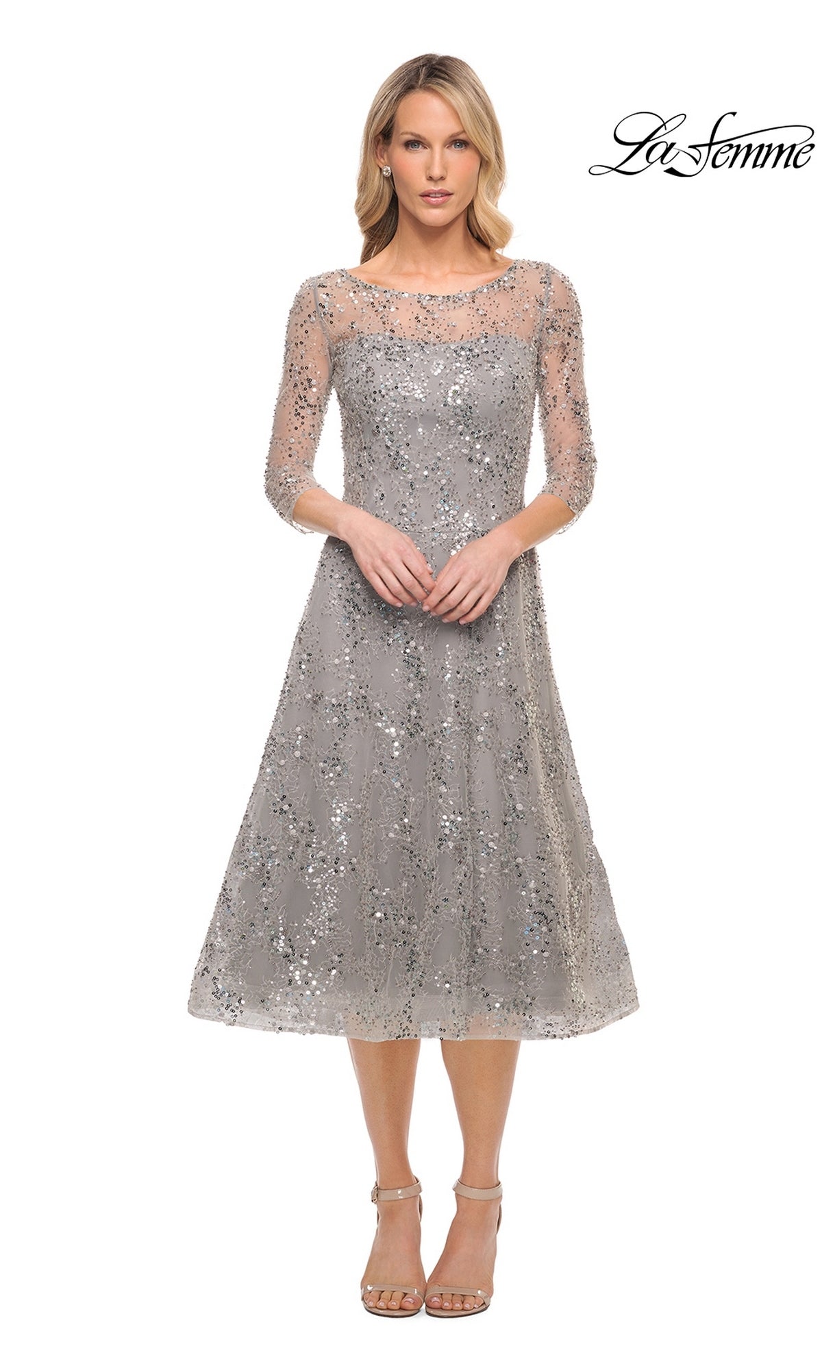 A woman wears a grey, fit-and-flare Midi Mother of Bride Dress: La Femme 30002 with three-quarter sleeves and all-over sequin embroidery, paired with neutral ankle-strap heels.
