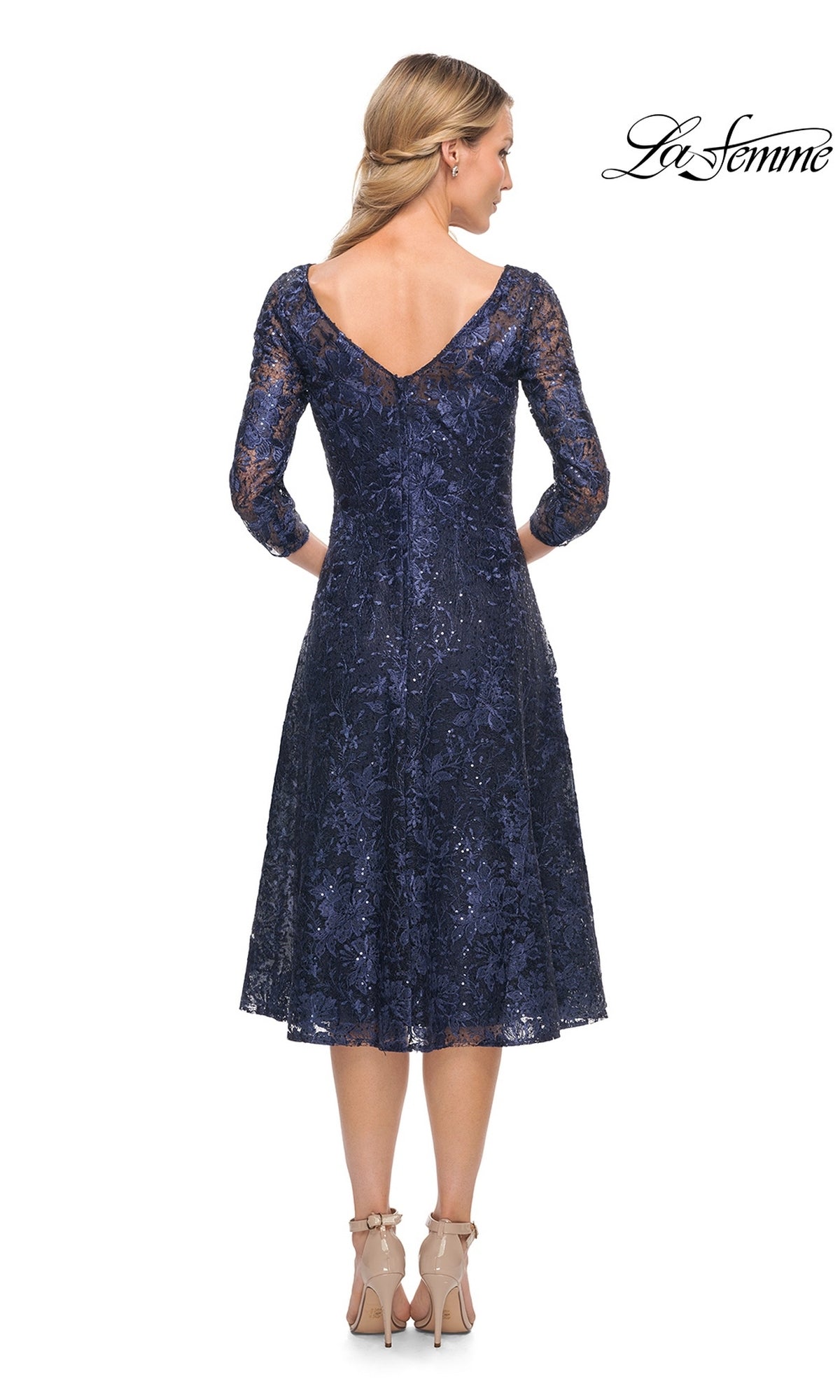 Back view of a woman wearing the Midi Wedding Guest Dress: La Femme 30005, a navy blue lace midi dress with three-quarter sleeves and a V-back.