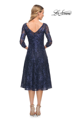 Back view of a woman wearing the Midi Wedding Guest Dress: La Femme 30005, a navy blue lace midi dress with three-quarter sleeves and a V-back.