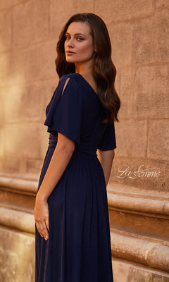 Woman in a Split-Sleeve Long Formal Dress: La Femme 30009 stands sideways against a textured stone wall, gracefully looking over her shoulder.
