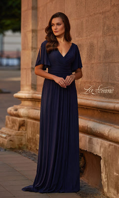 A woman stands outdoors by a stone wall in the La Femme 30009 Split-Sleeve Long Formal Dress—a navy blue evening gown featuring short split sleeves, a V-neckline, and an elegant floor-length A-line silhouette.