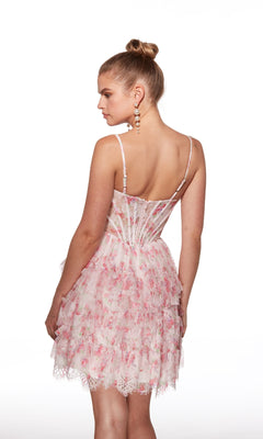 A woman in the Alyce 30009 pink floral lace fit-and-flare short homecoming dress with thin straps and a tiered ruffle skirt stands facing away, looking over her shoulder.