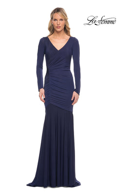 A woman wears a navy Long Formal Dress: La Femme 30010, a long-sleeve mermaid gown featuring a V-neckline and gathered detailing at the side of the waist.