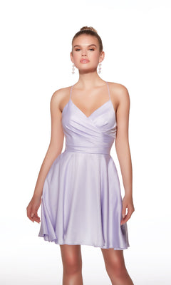 A woman stands against a white background wearing the Alyce Paris Strappy-Back Short A-Line Hoco Dress (Style 30018), featuring thin straps, a sleeveless design, and a flared skirt in light purple.