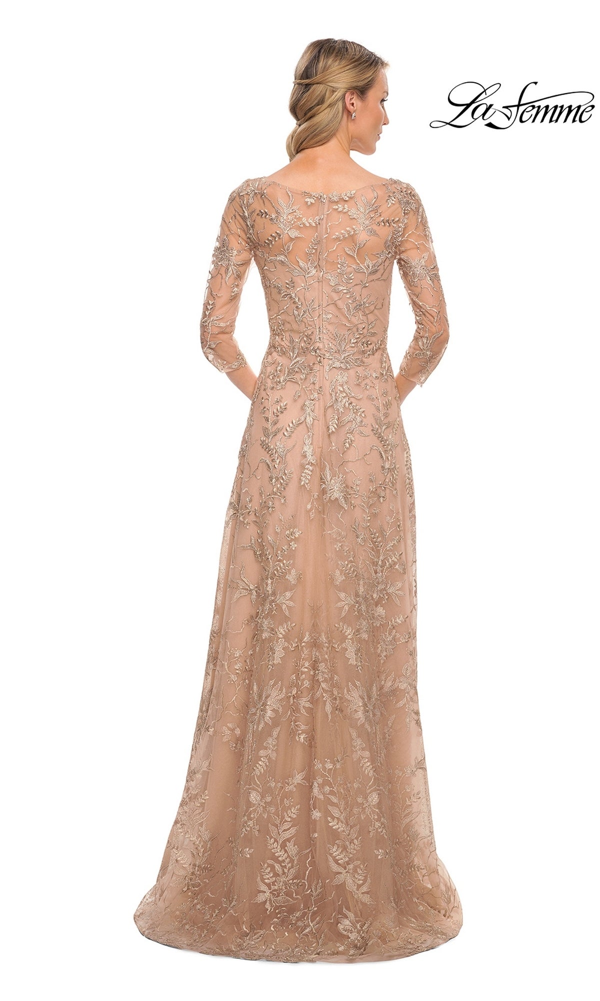 A woman viewed from behind wearing a floor-length, long-sleeved beige La Femme 30021 gown with metallic floral lace embroidery.