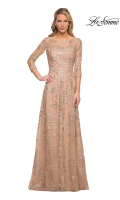 A woman wears the Long Formal Dress: La Femme 30021, a long, nude-gold formal dress with three-quarter sleeves and delicate floral lace embroidery.