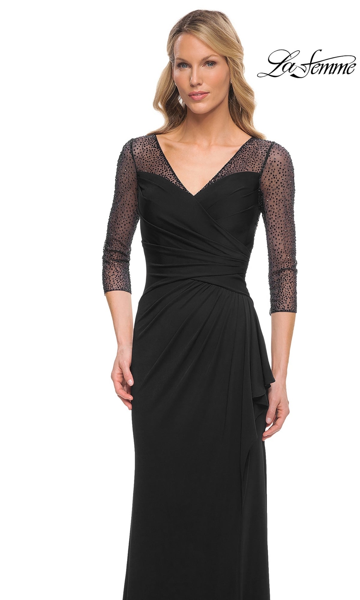 Woman wears Long Formal Dress: La Femme 30028—black jersey with sheer, beaded applique sleeves and V-neckline. “La Femme” logo appears top right. White background.