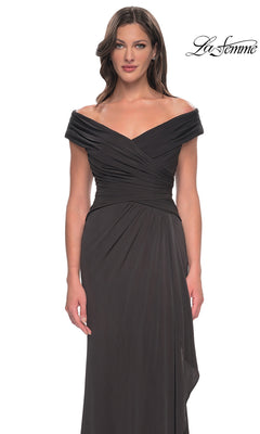 Woman in an off-shoulder v-neck, floor-length black La Femme 30040 with ruched bodice, standing against a white background. “La Femme” logo at top right.