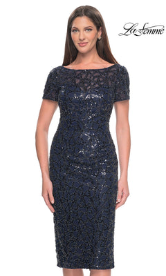 The Knee Length Wedding Guest Dress: La Femme 30043 is a knee-length, navy sequin sheath dress featuring a sheer neckline, short sleeves, and an all-over beaded pattern.