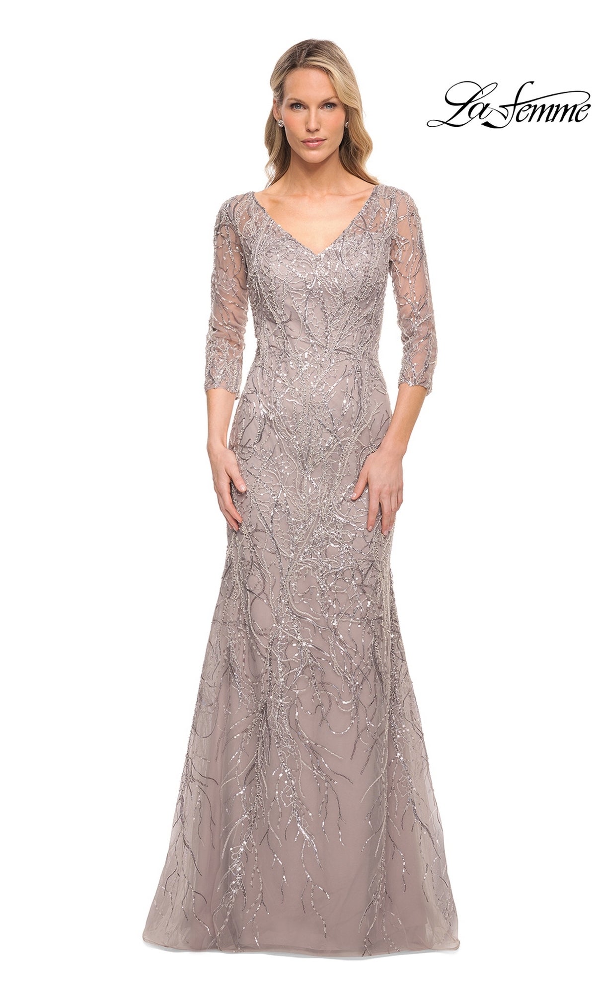 A woman wears the Long Formal Dress: La Femme 30044 in lavender-gray, featuring a V-neckline, three-quarter sleeves, and intricate silver sequin branch patterns.