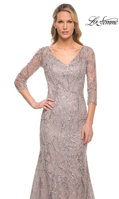A woman wearing a taupe, v-neck, three-quarter sleeve La Femme 30044 modest long formal dress embellished with silver sequins in a swirling pattern.